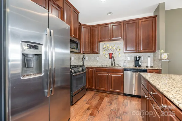 a kitchen with stainless steel appliances granite countertop a refrigerator and a sink
