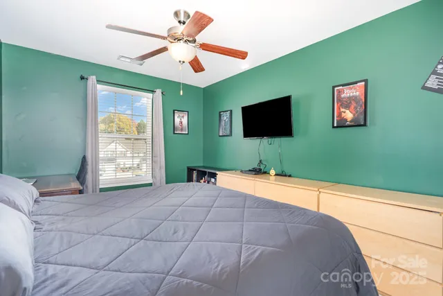 a bedroom with a bed and a flat screen tv