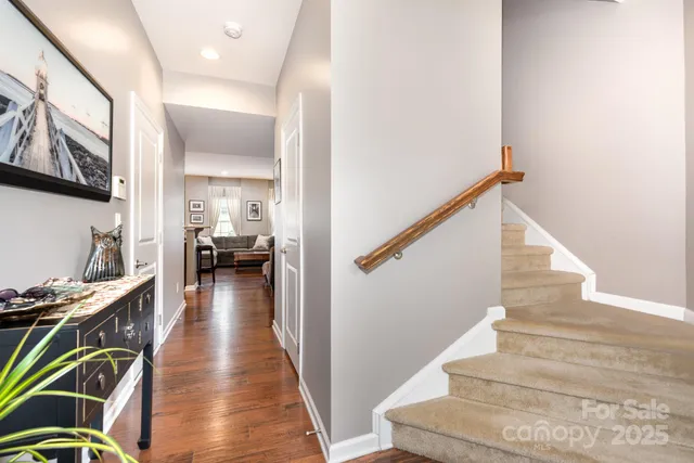 a view of a hallway with wooden floor and staircase