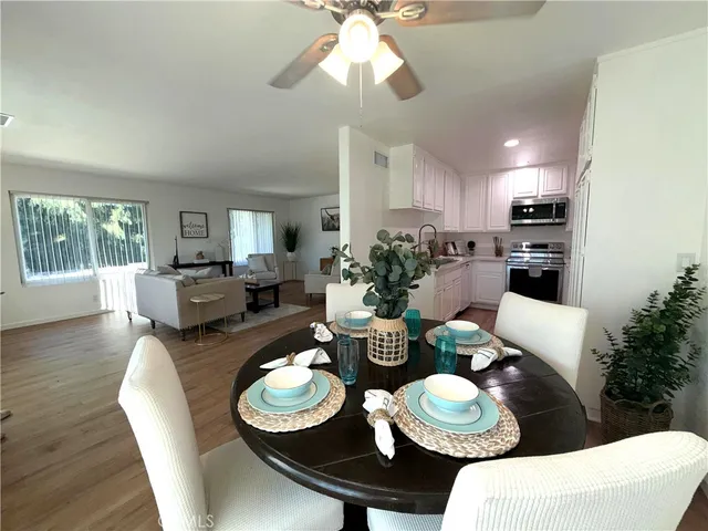 a dining room with furniture a large window and wooden floor