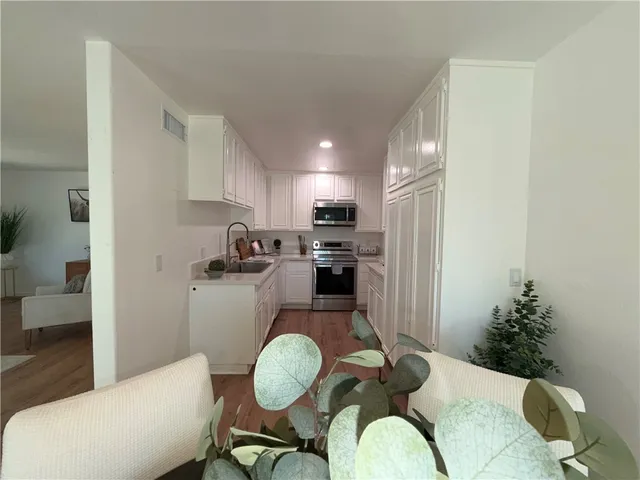a kitchen with sink refrigerator dining table and chairs