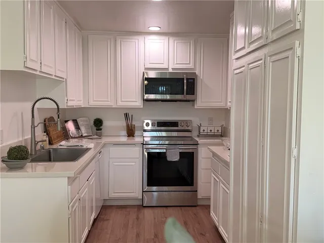 a kitchen with stainless steel appliances granite countertop a sink and a stove top oven