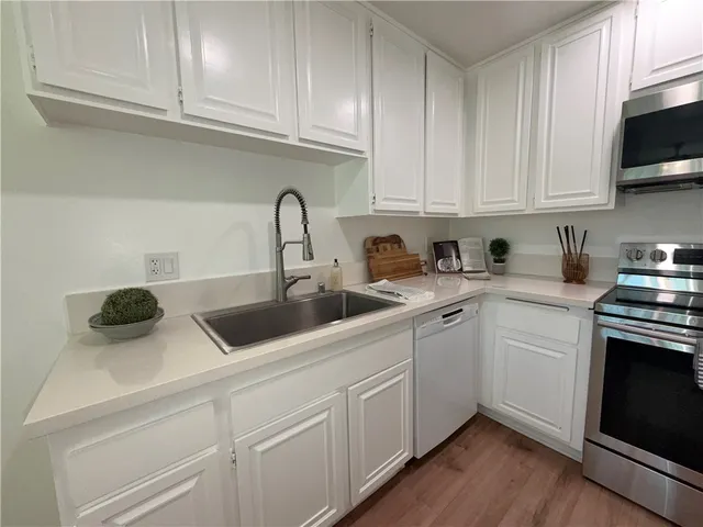 a kitchen with white cabinets and white appliances