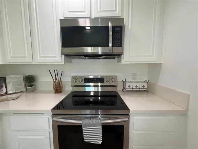 a kitchen with stainless steel appliances a stove a microwave and cabinets