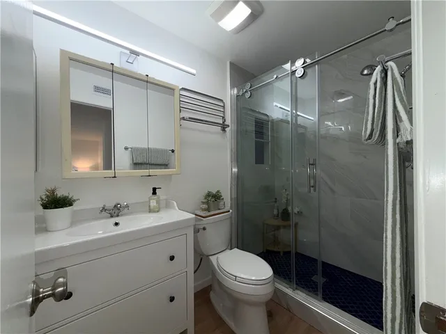 a bathroom with a sink a toilet and shower
