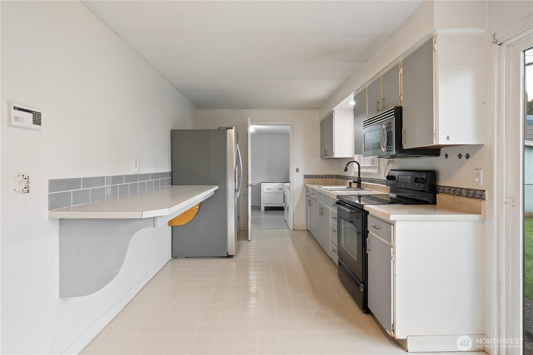 359 Douglas Street Longview, WA 98632 - Photo 14 of 29 a kitchen with stainless steel appliances white cabinets a sink a stove a refrigerator and a microwave