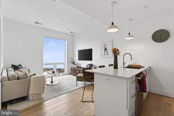 a living room with furniture a flat screen tv and a large window