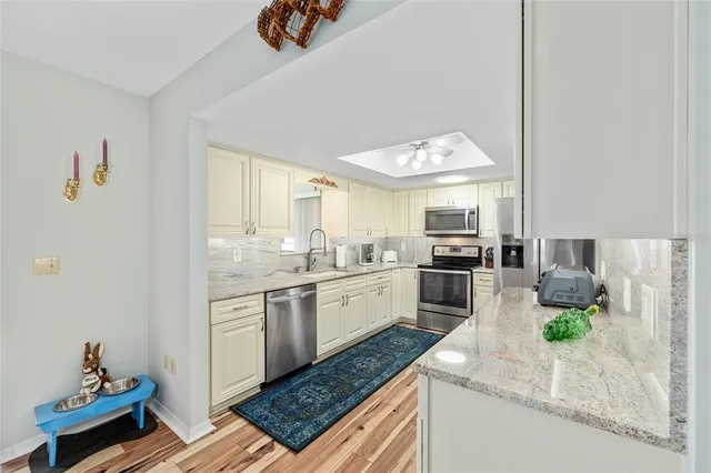 a kitchen with stainless steel appliances granite countertop a stove a sink and a refrigerator