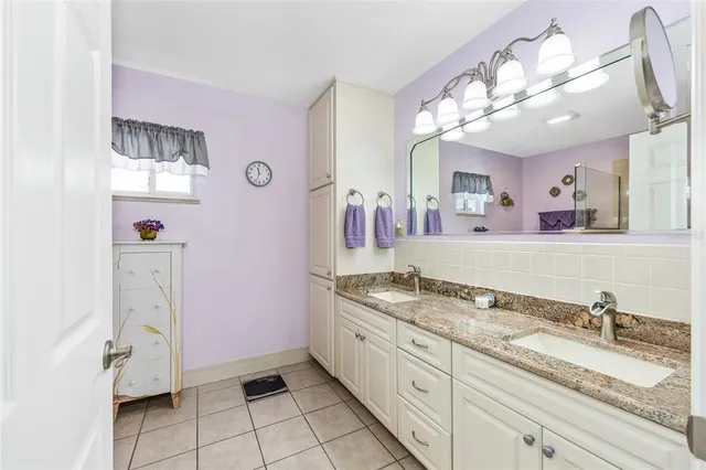 a spacious bathroom with a granite countertop sink and a mirror