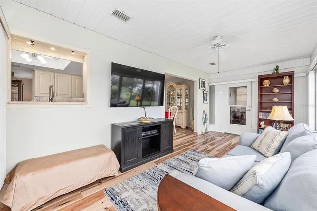 a living room with furniture a flat screen tv and a floor to ceiling window