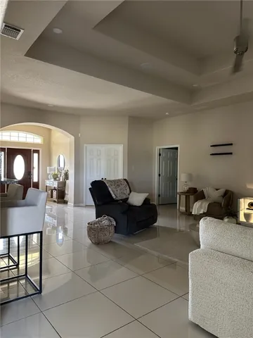 a living room with furniture a mirror and a table