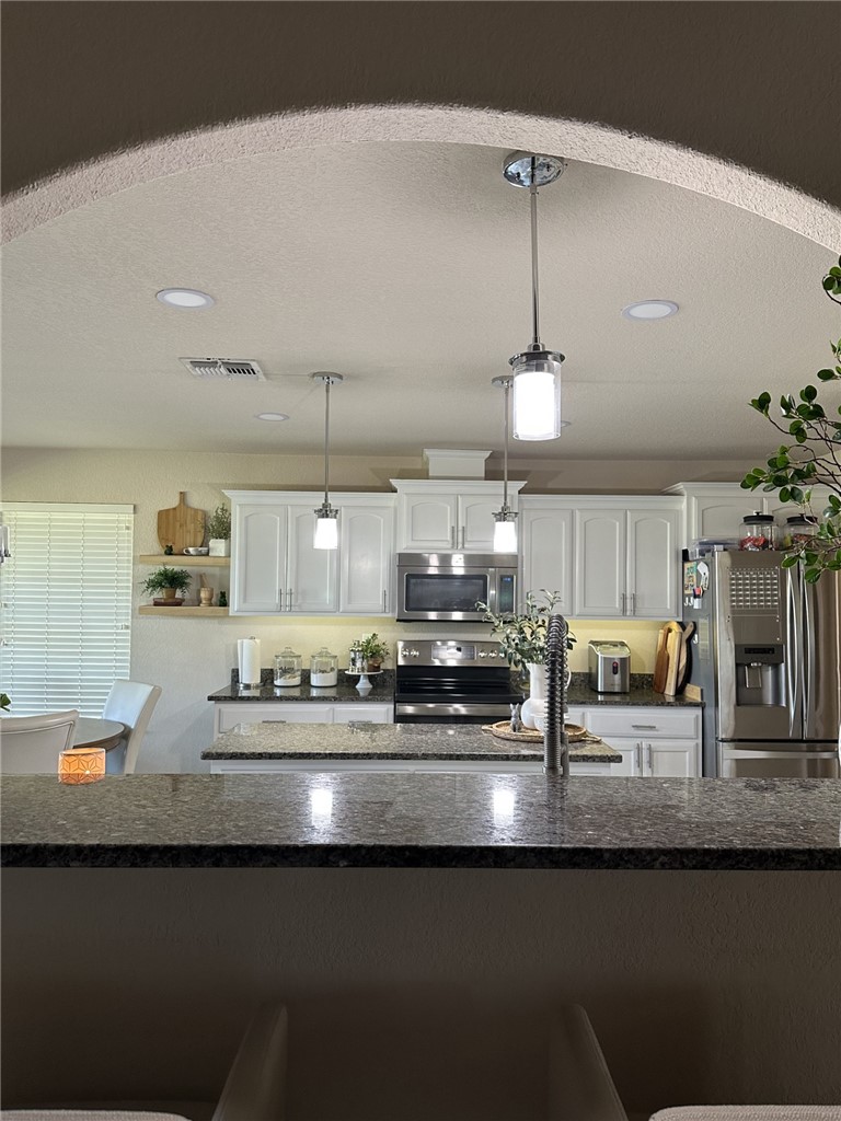 527 Coyote Ranch Alice, TX 78332 - Photo 7 of 17 a kitchen with stainless steel appliances granite countertop a sink a stove and a microwave oven