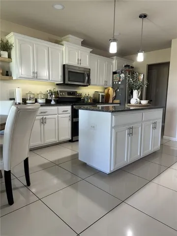 a kitchen with stainless steel appliances granite countertop a sink a stove a microwave and a refrigerator