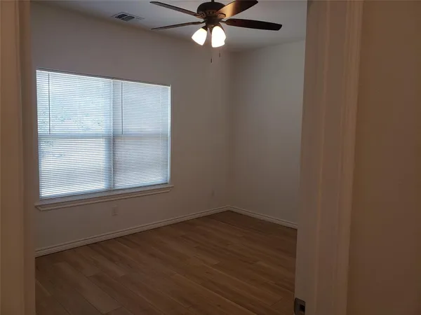 a view of an empty room with wooden floor