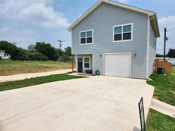 a view of a house with a yard and potted plants