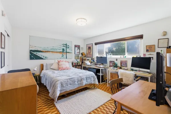 a bedroom with a bed and wooden floor