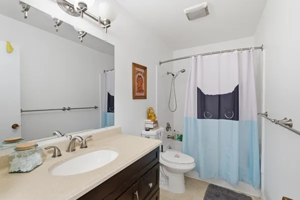 a bathroom with a sink vanity mirror and toilet