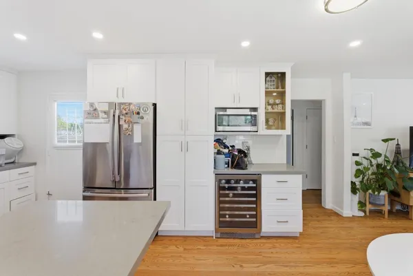 a view of kitchen with stainless steel appliances wooden floor and window