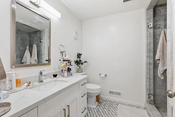 a bathroom with a sink a toilet and shower