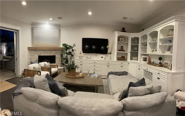 a living room with furniture a flat screen tv and a fireplace