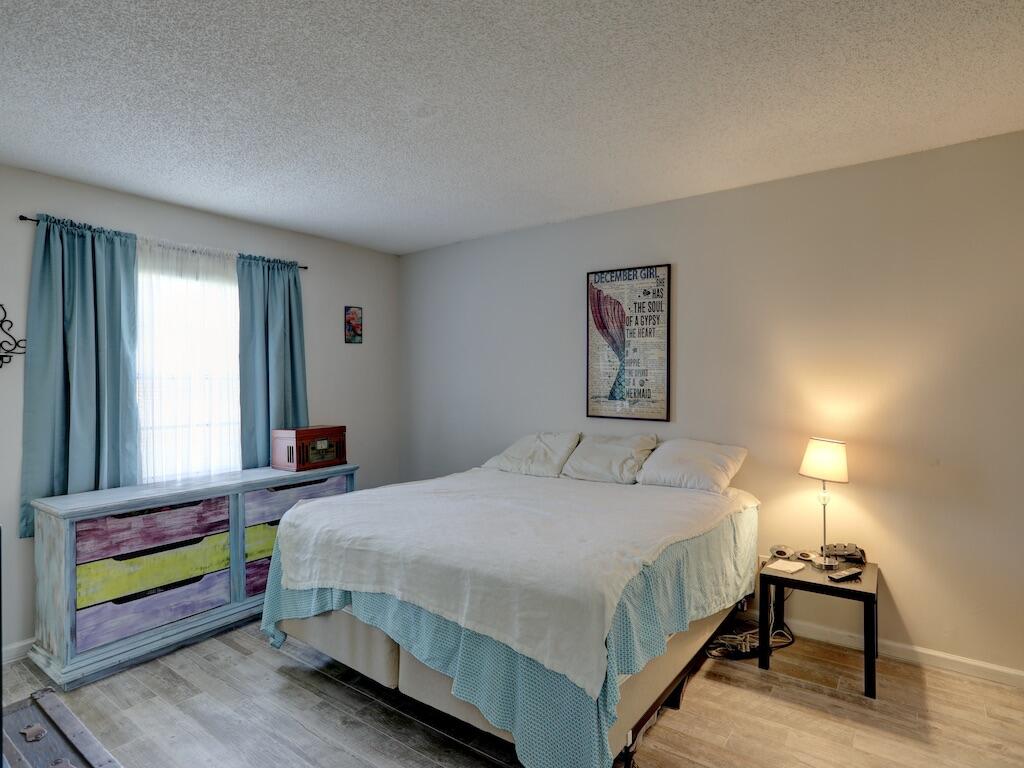 6022 Indrio Road, Unit 3 Fort Pierce, FL 34951 - Photo 21 of 35 a bedroom with a bed a window and painting on the wall