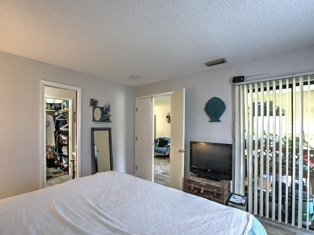 6022 Indrio Road, Unit 3 Fort Pierce, FL 34951 - Photo 23 of 35 a bedroom with a bed and a flat screen tv
