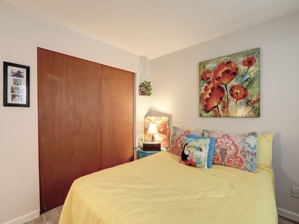 6022 Indrio Road, Unit 3 Fort Pierce, FL 34951 - Photo 28 of 35 a bedroom with a bed and a wall painting