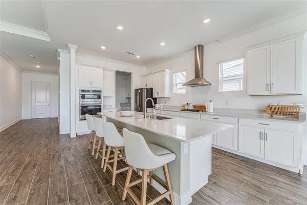 a kitchen with stainless steel appliances granite countertop a table chairs sink and cabinets