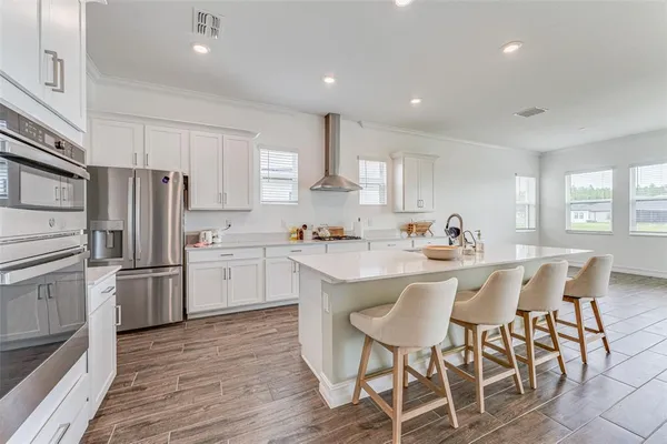 a kitchen with a sink stainless steel appliances and white cabinets