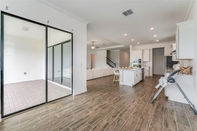 a view of a kitchen with wooden floor and electronic appliances