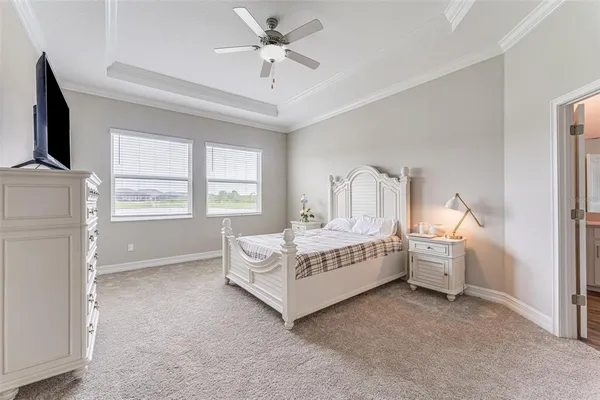 a spacious bedroom with a white bed and a chandelier