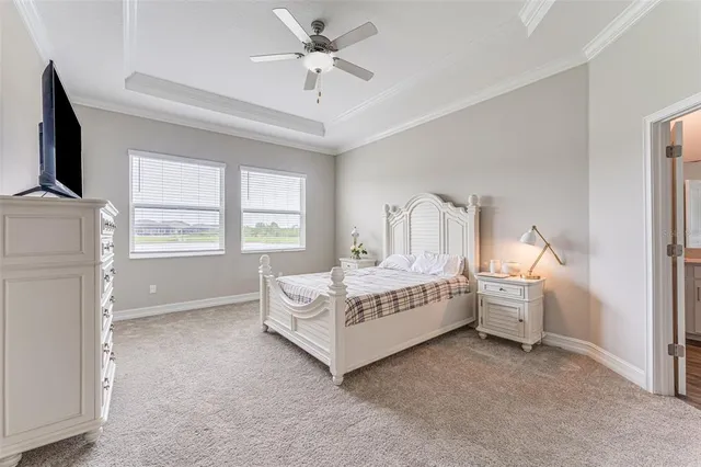 a spacious bedroom with a white bed and a chandelier