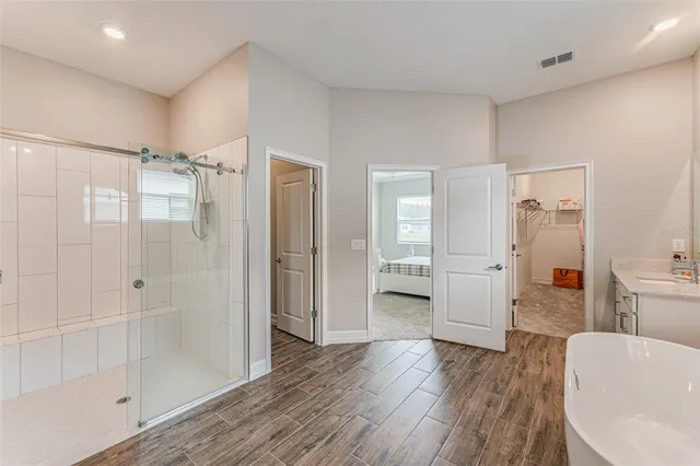a bathroom with a glass door shower a sink and a mirror