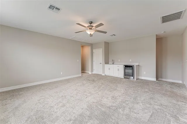 a view of an empty room with a ceiling fan