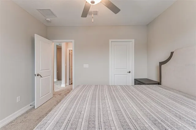 a view of a room with wooden floor a ceiling fan and window