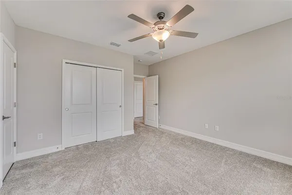 an empty room with a ceiling fan and a window