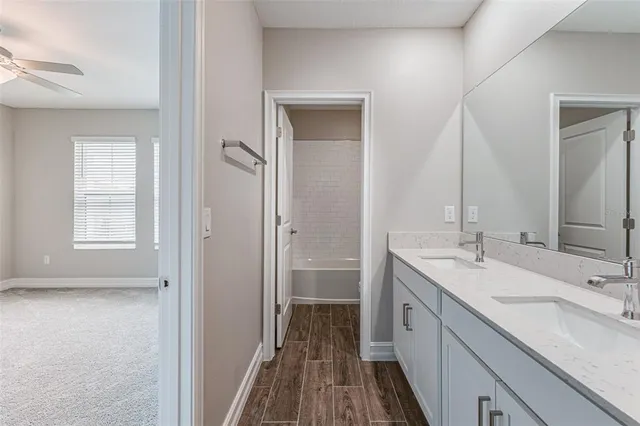 a spacious bathroom with a double vanity sink a mirror and a shower