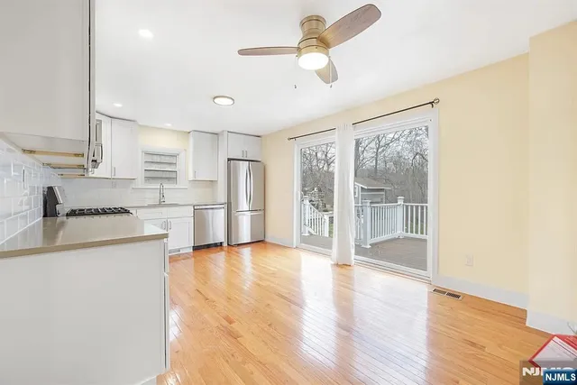 a view of a kitchen with wooden floor and a refrigerator