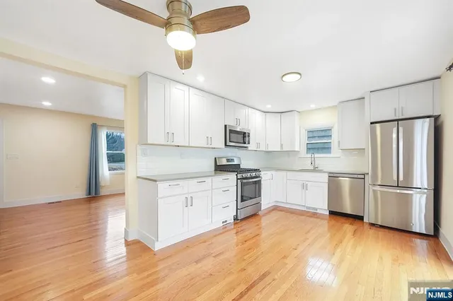a kitchen with a refrigerator cabinets and wooden floor