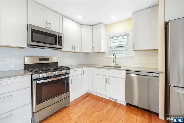 a kitchen with stainless steel appliances granite countertop a stove microwave and sink