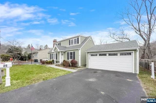 a front view of a house with a garden and yard
