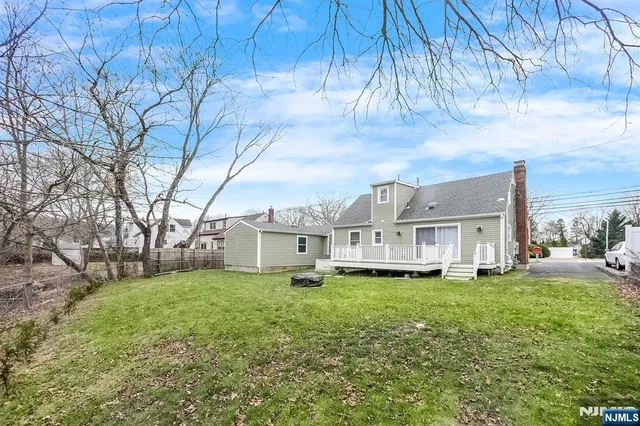 a view of a house with a big yard and large trees