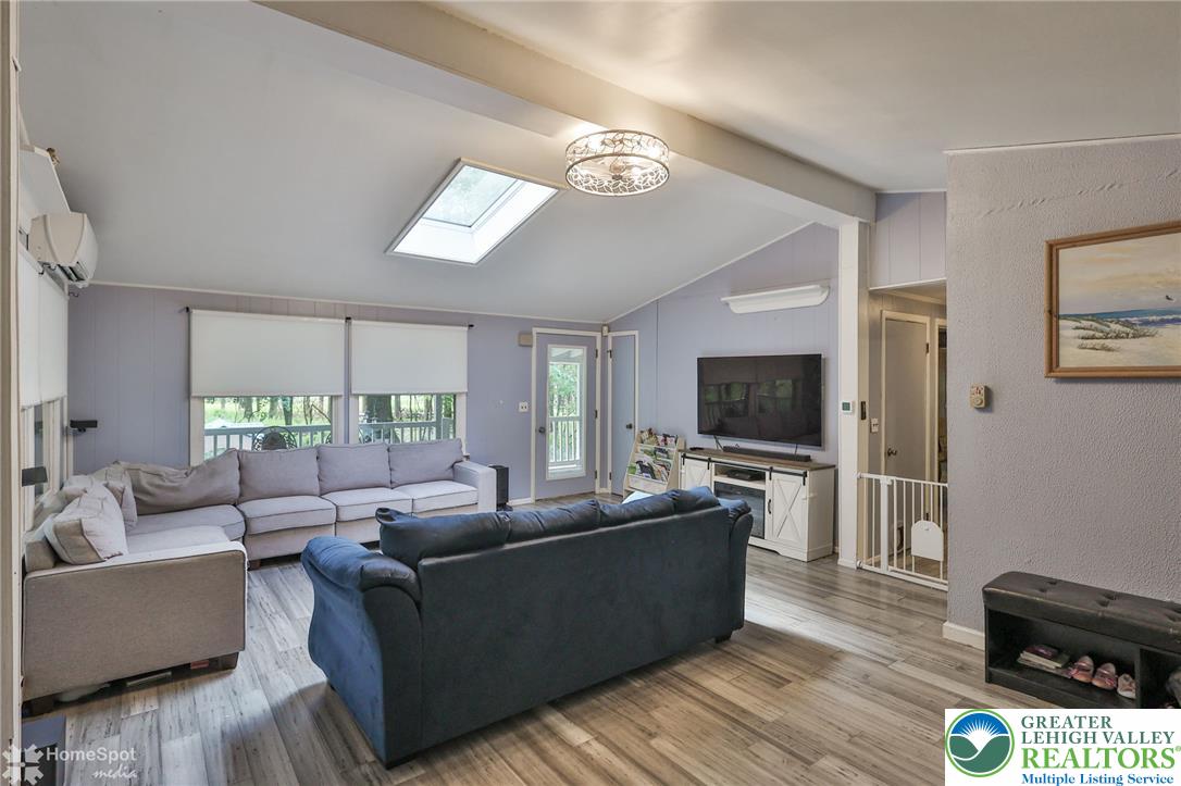 60 Sassafras Road Lehighton, PA 18235 - Photo 19 of 36 Natural light floods this living space, featuring a vaulted ceiling and skylight.
