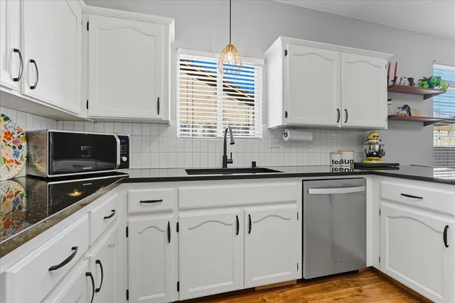 a kitchen with white cabinets and white appliances