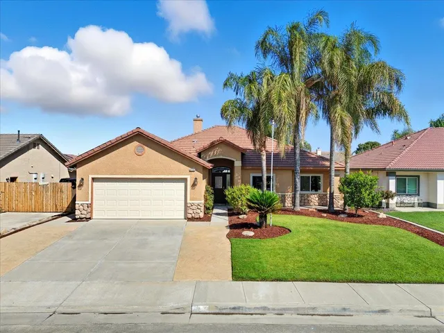 a front view of a house with a yard and trees