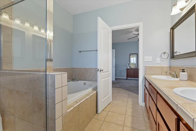 a bathroom with a tub sink and mirror
