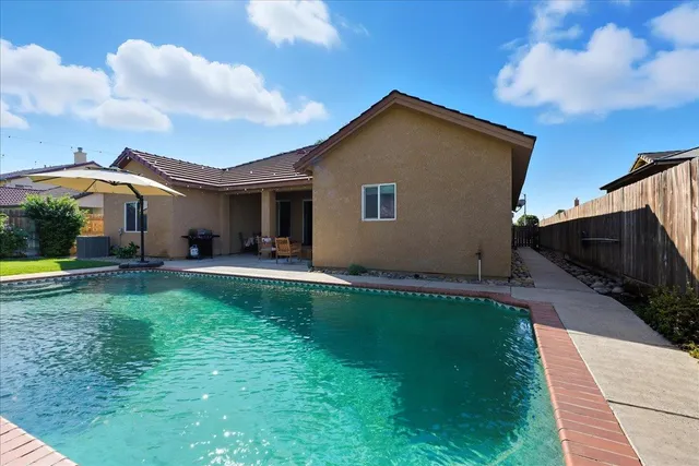 a backyard of a house with table and chairs