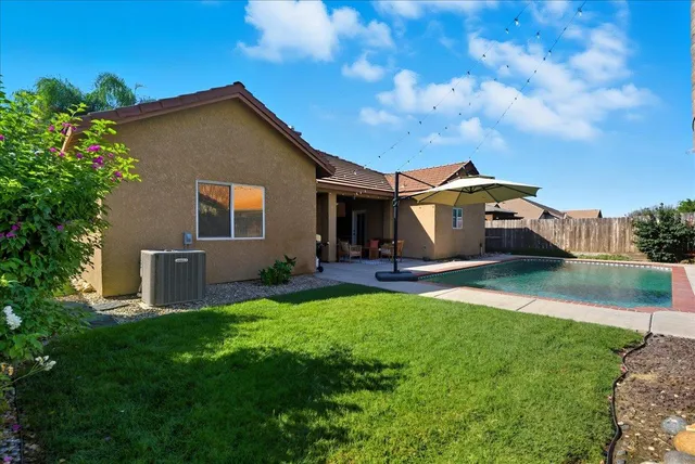 a front view of a house with yard and a tree