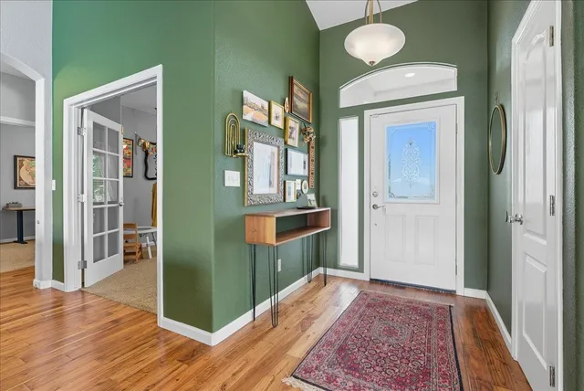 a view of a hallway with wooden floor and staircase