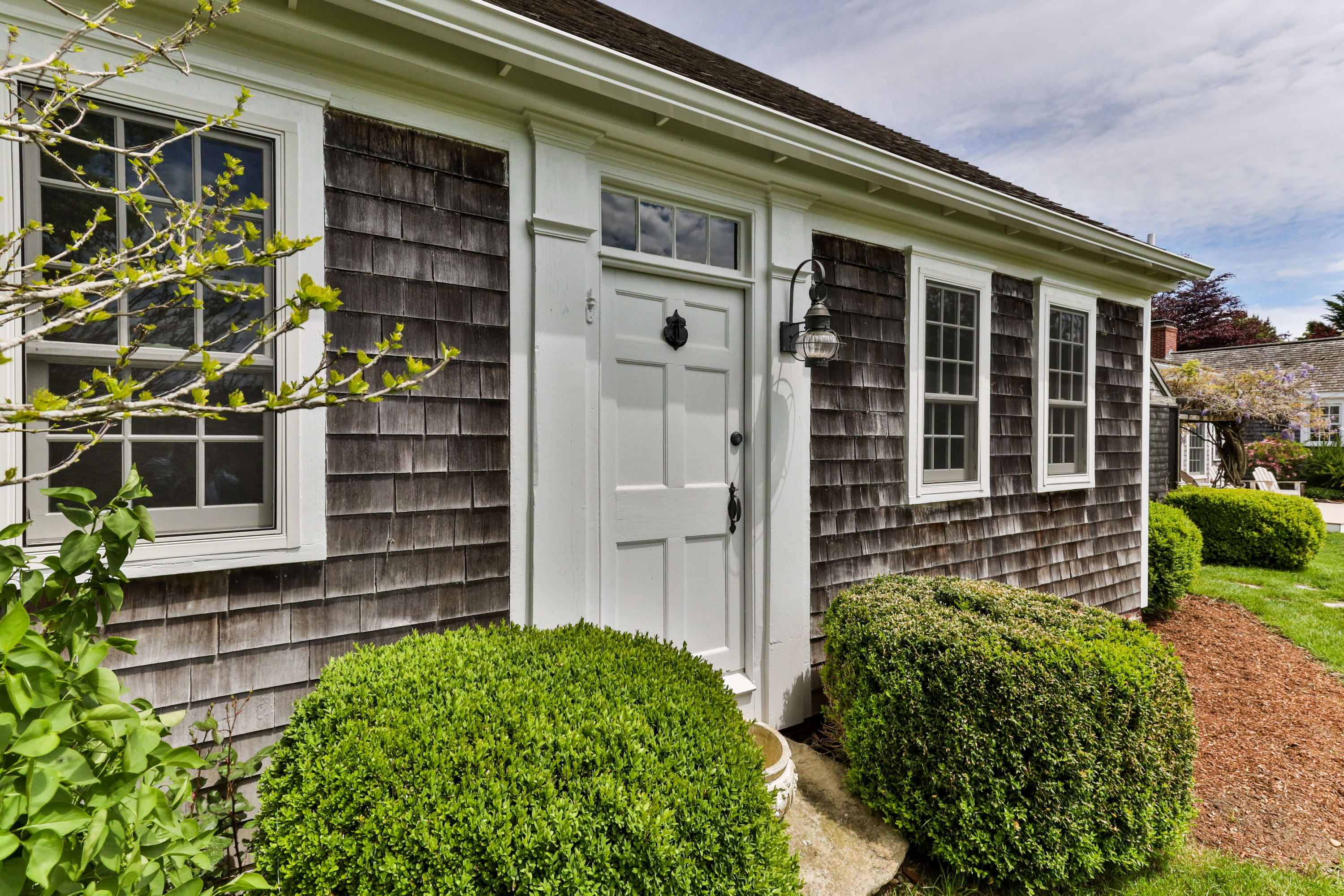 91 Castle Road Truro, MA 02666 - Photo 65 of 78 front view of a house with a large window and potted plants